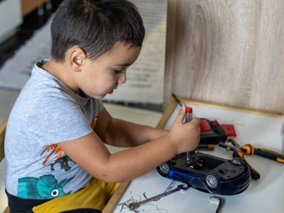 free photo of boy assembling a car model