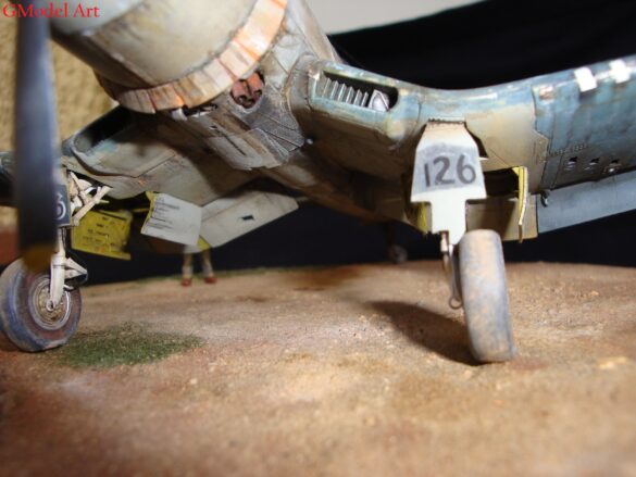 "Heavily weathered underside of F4U-1 Corsair 126 with realistic oil and dust effects simulating coral strip operations".