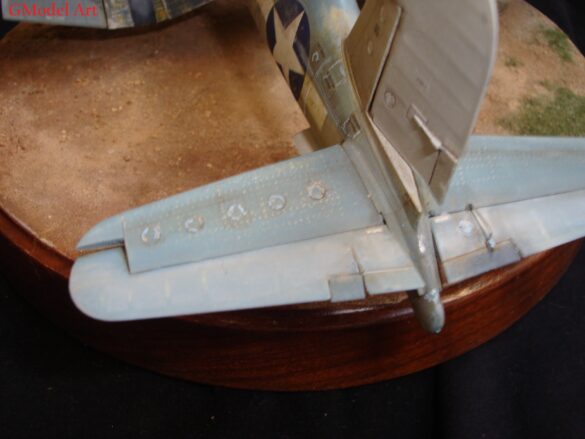 "Heavily weathered underside of F4U-1 Corsair 126 with realistic oil and dust effects simulating coral strip operations".