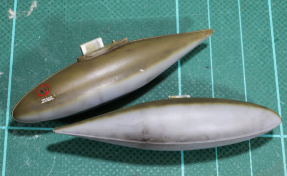 Photo Gallery – Tamiya 1/48 P-38G Lightning by Chris Wauchop Radio compartment detailing using 0.2 mm and 0.3 mm wire – painted placards and realistic wiring. Supercharger units finished with layered metallic and brown/black shades for realistic depth. Fuselage underside showing grime wash and added hydraulic brake lines. Drop tanks weathered for operational realism, mounted underwing. Panel line seal tape simulation using airbrush fading and masking techniques. Camouflage tones stippled for realistic weathered surface finish. Paint wear and black exhaust marks enhance visual realism. Cockpit close-up with foil-made harness and mirror wire control. Wing underside shows soot, staining, and sealing tape simulation. Tail surfaces display extensive weathering and exhaust wear effects.