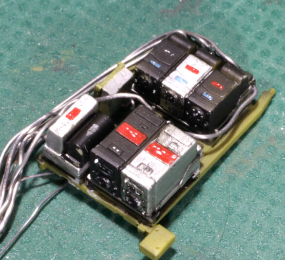 Photo Gallery – Tamiya 1/48 P-38G Lightning by Chris Wauchop Radio compartment detailing using 0.2 mm and 0.3 mm wire – painted placards and realistic wiring. Supercharger units finished with layered metallic and brown/black shades for realistic depth. Fuselage underside showing grime wash and added hydraulic brake lines. Drop tanks weathered for operational realism, mounted underwing. Panel line seal tape simulation using airbrush fading and masking techniques. Camouflage tones stippled for realistic weathered surface finish. Paint wear and black exhaust marks enhance visual realism. Cockpit close-up with foil-made harness and mirror wire control. Wing underside shows soot, staining, and sealing tape simulation. Tail surfaces display extensive weathering and exhaust wear effects.