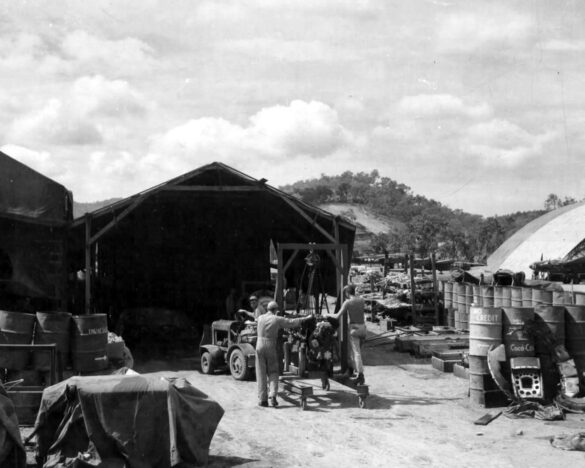 alt="1/48 scale Pacific airfield diorama with PSP and fuel truck" alt="US WW2 bomb cart and drums beside F4U Corsair" alt="Ground crew and maintenance scene on jungle runway" alt="Diorama showing GMC fuel bowser and PSP strip" alt="Scale model US bomb hoist in tropical airfield setting"