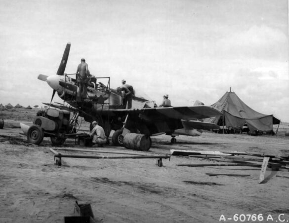 "1/48 scale Pacific airfield diorama with PSP and fuel truck" alt="US WW2 bomb cart and drums beside F4U Corsair" alt="Ground crew and maintenance scene on jungle runway" alt="Diorama showing GMC fuel bowser and PSP strip" alt="Scale model US bomb hoist in tropical airfield setting"