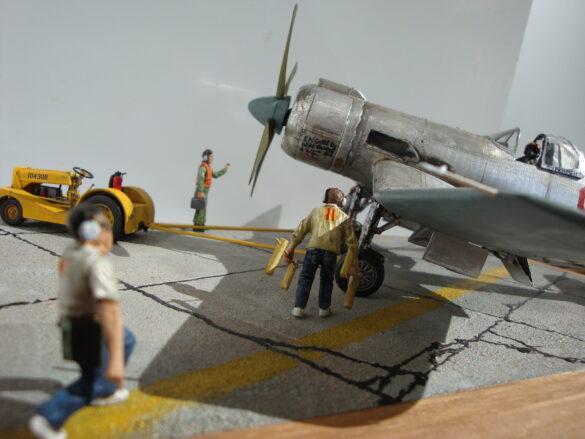 FG-1D Corsair #94-“Big Hummer” at Reno 1971 / Pilot ~ Bob Mitchem. FG-1D Corsair “Big Hammer” – 1/48 model with aluminum foil skin, four-blade prop, Hasegawa carrier crew figures, and scratch-built diorama base, depicting a Reno 1971 scene.