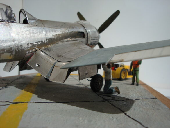 FG-1D Corsair #94-“Big Hummer” at Reno 1971 / Pilot ~ Bob Mitchem. FG-1D Corsair “Big Hammer” – 1/48 model with aluminum foil skin, four-blade prop, Hasegawa carrier crew figures, and scratch-built diorama base, depicting a Reno 1971 scene.
