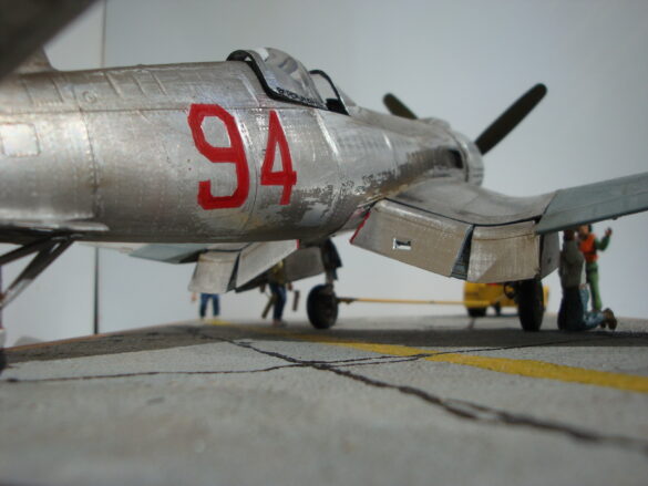 FG-1D Corsair #94-“Big Hummer” at Reno 1971 / Pilot ~ Bob Mitchem. FG-1D Corsair “Big Hammer” – 1/48 model with aluminum foil skin, four-blade prop, Hasegawa carrier crew figures, and scratch-built diorama base, depicting a Reno 1971 scene.