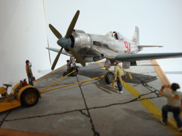 FG-1D Corsair #94-“Big Hummer” at Reno 1971 / Pilot ~ Bob Mitchem. FG-1D Corsair “Big Hammer” – 1/48 model with aluminum foil skin, four-blade prop, Hasegawa carrier crew figures, and scratch-built diorama base, depicting a Reno 1971 scene.