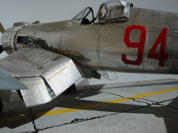 FG-1D Corsair #94-“Big Hummer” at Reno 1971 / Pilot ~ Bob Mitchem. FG-1D Corsair “Big Hammer” – 1/48 model with aluminum foil skin, four-blade prop, Hasegawa carrier crew figures, and scratch-built diorama base, depicting a Reno 1971 scene.