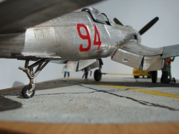 FG-1D Corsair #94-“Big Hummer” at Reno 1971 / Pilot ~ Bob Mitchem. FG-1D Corsair “Big Hammer” – 1/48 model with aluminum foil skin, four-blade prop, Hasegawa carrier crew figures, and scratch-built diorama base, depicting a Reno 1971 scene.