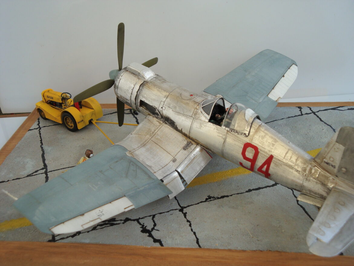 FG-1D Corsair “Big Hammer” – 1/48 model with aluminum foil skin, four-blade prop, Hasegawa carrier crew figures, and scratch-built diorama base, depicting a Reno 1971 scene.