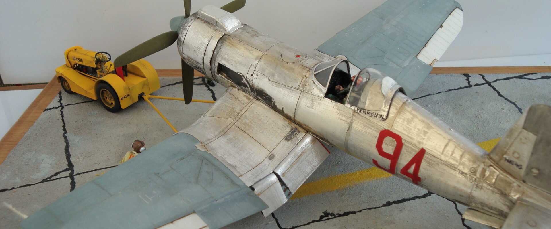 FG-1D Corsair “Big Hammer” – 1/48 model with aluminum foil skin, four-blade prop, Hasegawa carrier crew figures, and scratch-built diorama base, depicting a Reno 1971 scene.