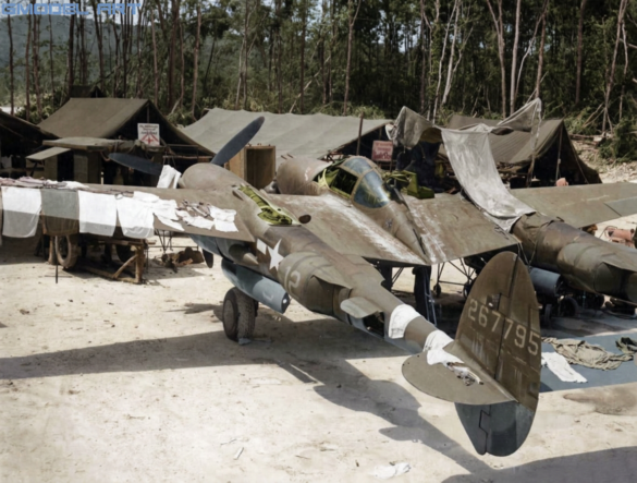 Damaged Lockheed P-38 Lightning abandoned on a tropical Pacific airfield